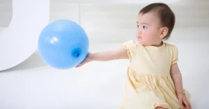 bebé juega con globo